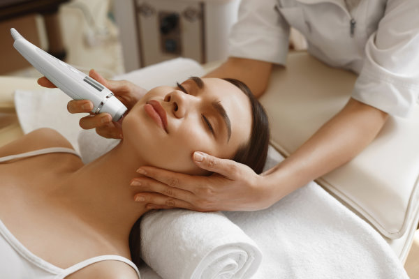 Skin Care. Beautiful Healthy Woman Getting Her Skin Analized By Cosmetologist, Using Skin Analyzer ( Professional Beauty Equipment ) For Face Skin Analysis At Cosmetology Center. High Resolution Image